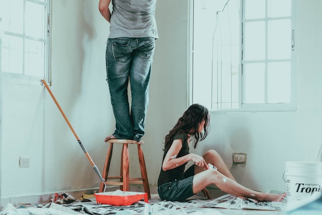 First-time home buyers painting and decorating their walls white.